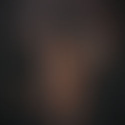 Woman in black lace lingerie and veil, seated with candles in the background. Mood is intimate and mysterious, set in a dimly lit room.