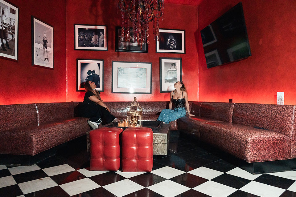 Girls trip portrait session in the red interior of The Saint Hotel Burgundy Bar