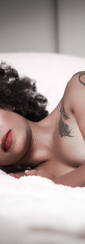 african american woman in bed laying boudoir pose. Boudoir photography new orleans