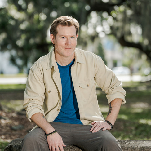 Outdoor personal brand session with a professional seated on a park bench in City Park
