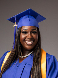 Female healthcare graduate photographed against a grey backdrop with professional studio lighting.