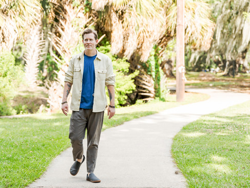 Branding session portrait with relaxed pose in a landscaped area of City Park