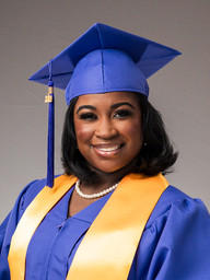 Healthcare program graduate wearing purple and gold during an on-location portrait session at New Orleans East Hospital.