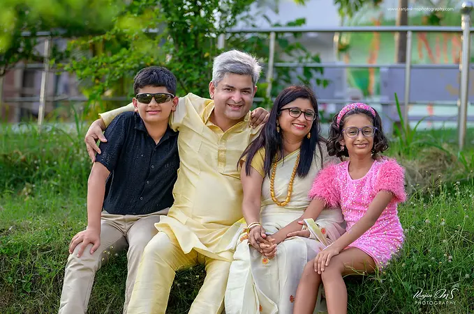 Outdoor family portrait in Deoghar with parents and two children, professionally captured with creative lighting by Ranjan KM's Photography.