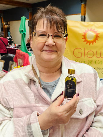 A woman holds a bottle of Extreme Hair Growth Oil
