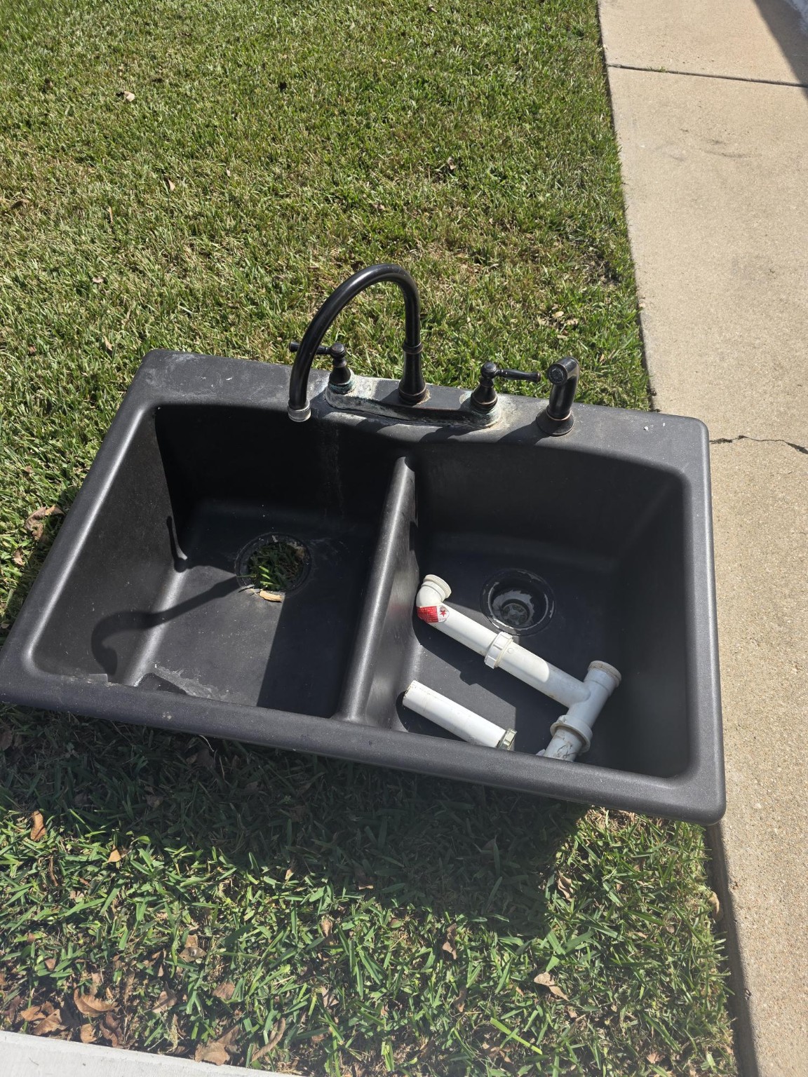 Original black double-bowl kitchen sink and faucet after removal