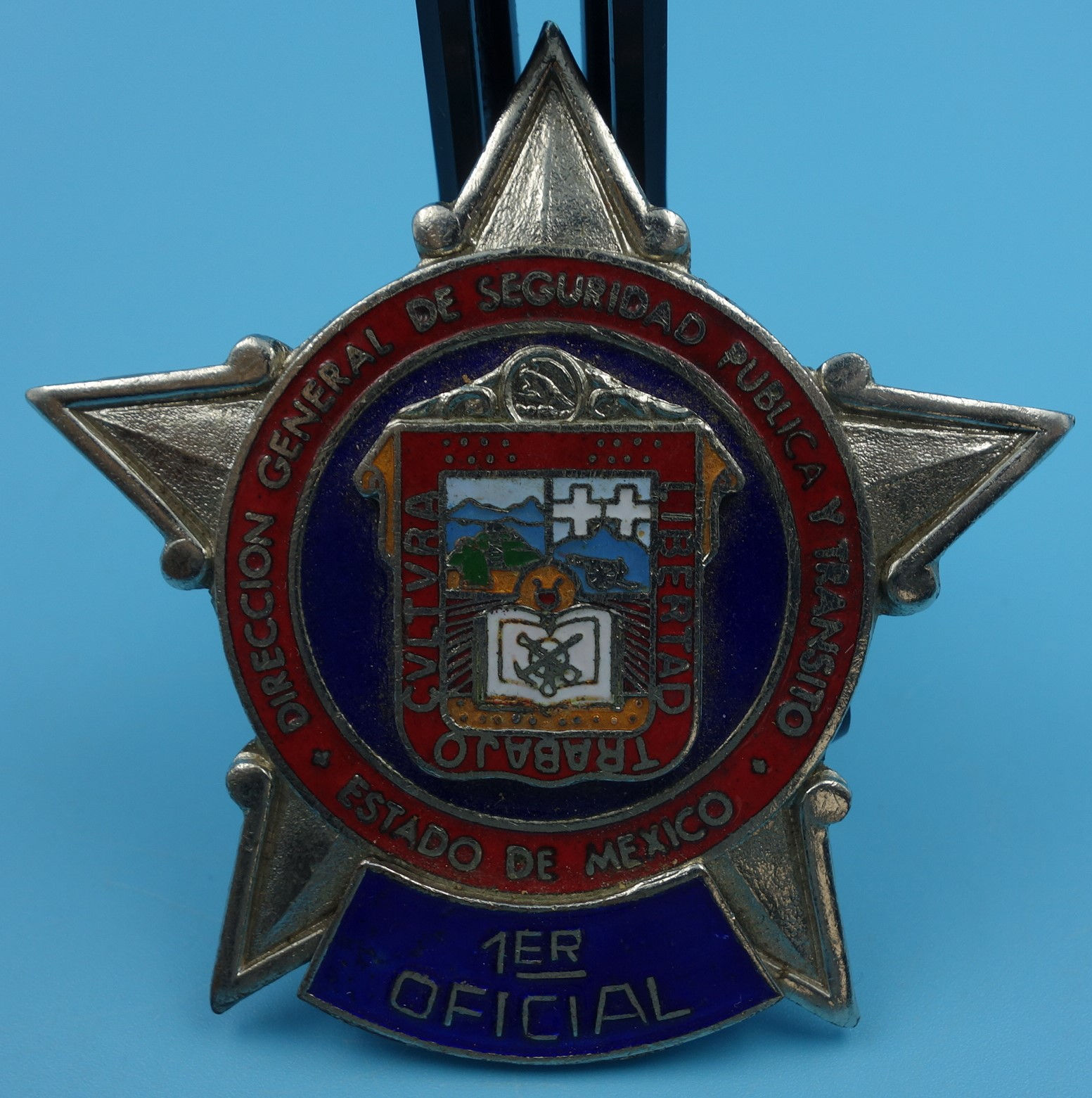Silver star-shaped Mexican army badge: "1er Oficial"
