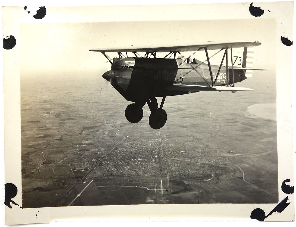Vintage biplane flying over city