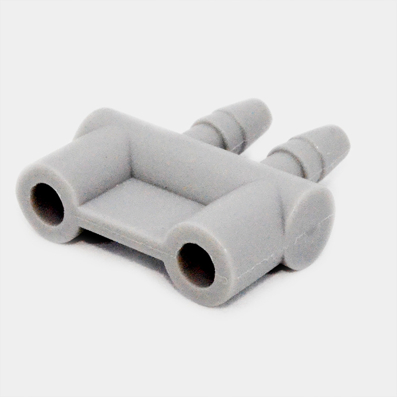 Conector gris de plástico con dos entradas y salidas, Acople Ohmeda para aire.