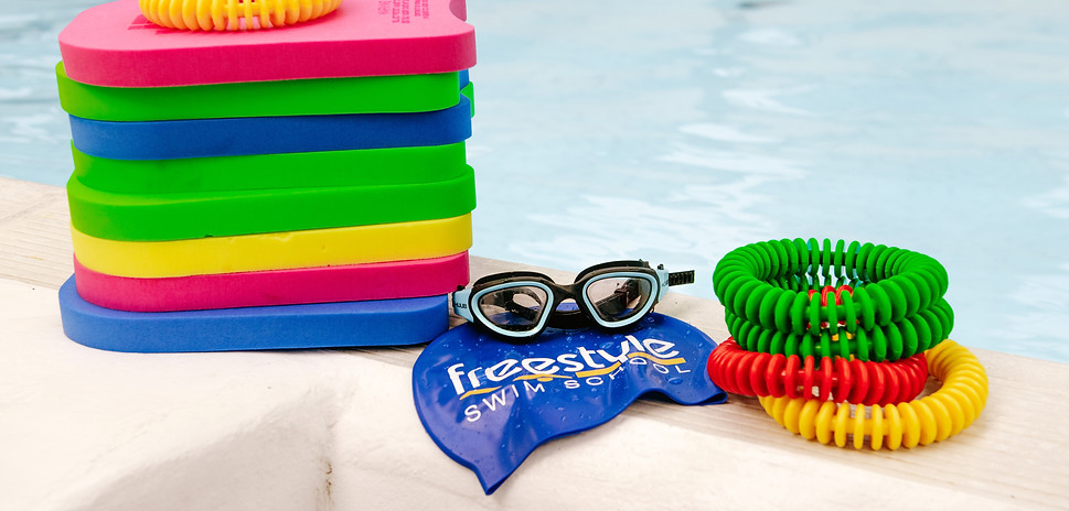 swimming floats , goggles and sinkers on the side of a swimming pool