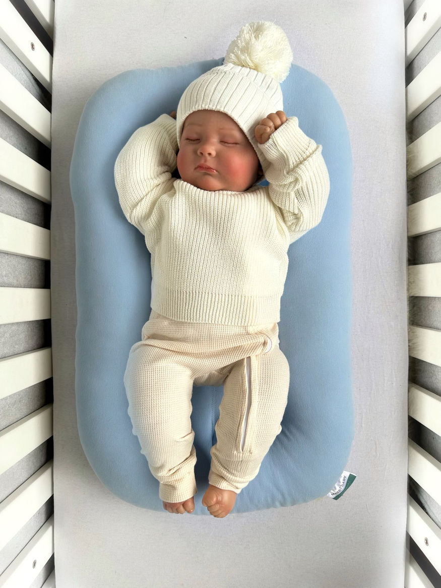 Кокон для новонароджених NEWBORN світло-блакитний з дитиною в білому одязі