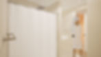 Modern bathroom with walk-in shower, eco-friendly fixtures, and neutral stone finishes