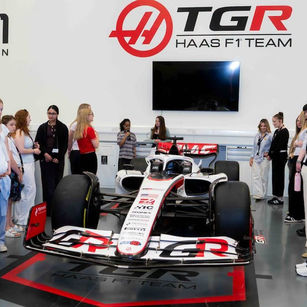 SUTC students gathered around the Haas F1 car