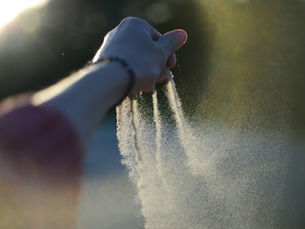 A hand releasing sand
