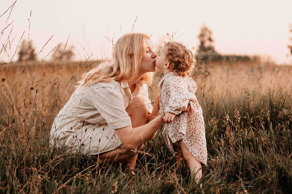 Eine Mutter gibt ihrem kleinen Kind einen liebevollen Kuss in einem sonnigen Feld. Diese natürliche und emotionale Aufnahme von Linda Meile zeigt die enge Verbindung zwischen Mutter und Kind – ideal für Familienfotografie in Wil SG.