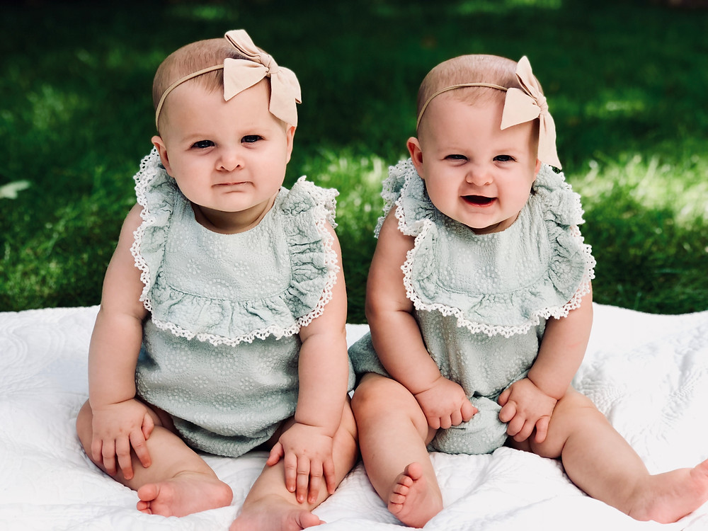 matching twin girls on blanket in grass