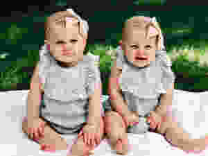 matching twin girls on blanket in grass