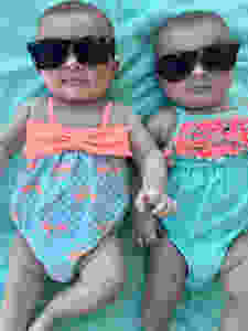Twin girls in sunglasses and swimsuits