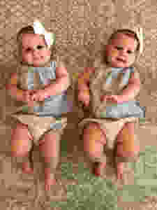 twin girls laying on playmat