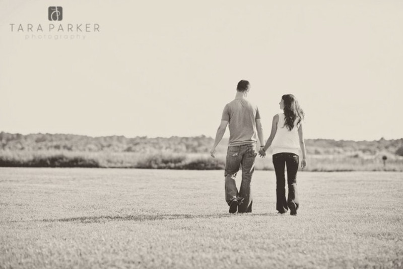girl and boy walking away from camera holding hands engagement photo