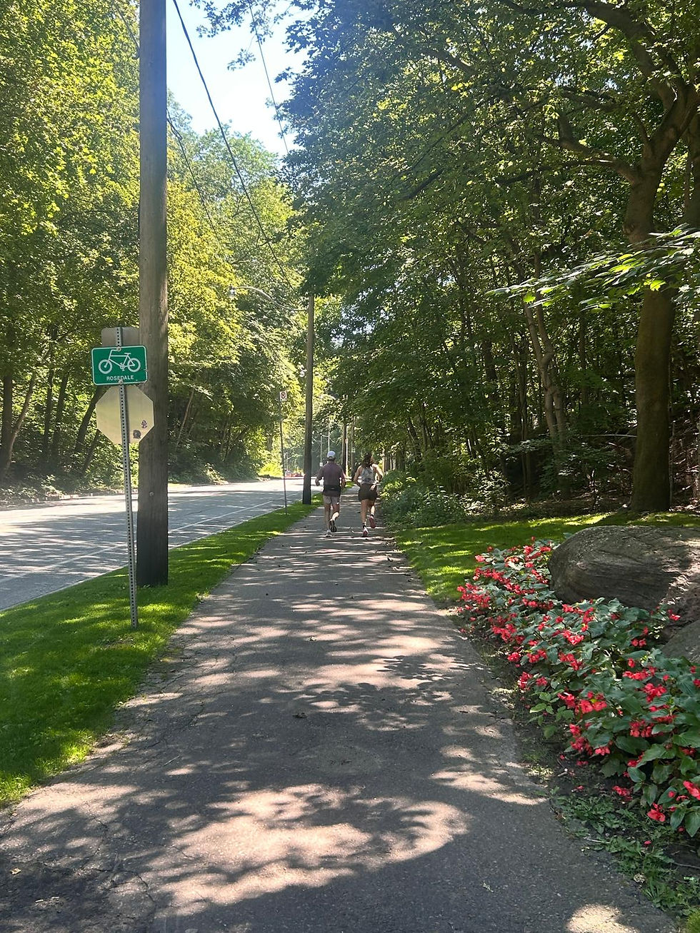 An elderly father and his daughter, jogging slowly along Rosedale Valley Road.