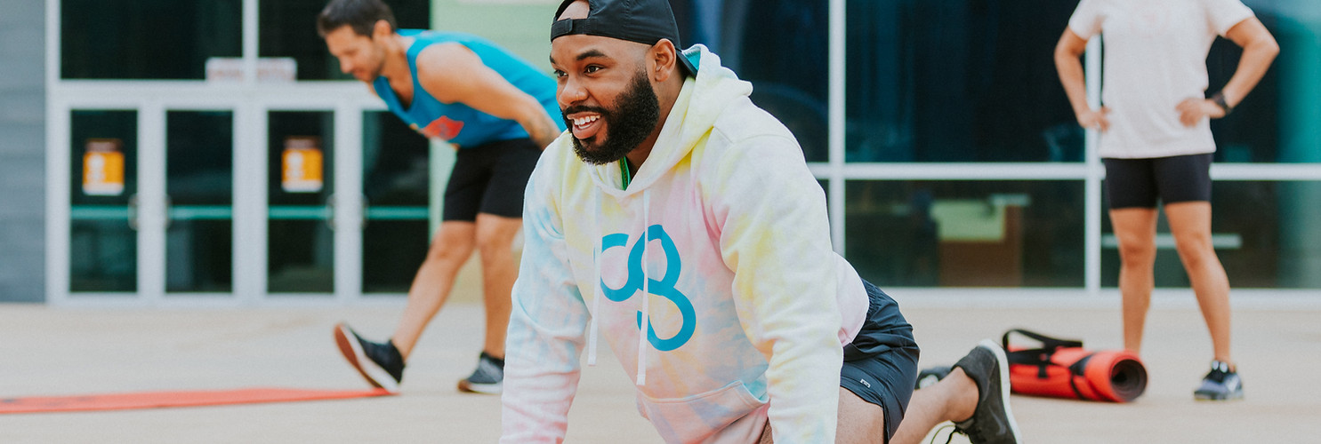 Group of athletes doing exercises on a mat CG logo Camp Gladiator