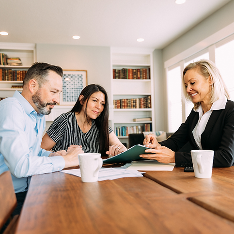 Couple reviewing financial documents with advisor