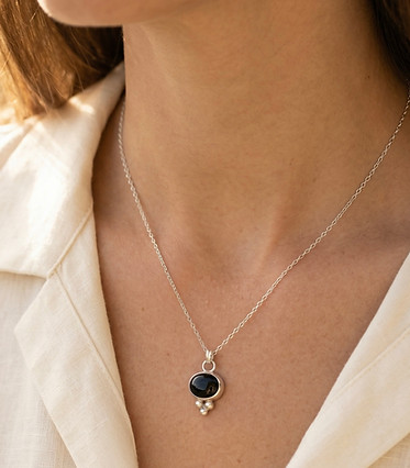 A dainty black onyx and recycled silver neck being worn