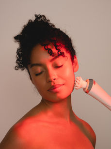 Creative beauty photography for Guinot Mary-Cohr by London beauty photographer Margot Jakobson, showing a model enjoying a red light facial treatment.