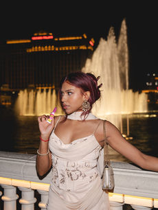 Beauty shot of Anjeni Khusul holding a NYX product in front of the Bellagio fountains for the NYX x Las Vegas campaign, taken by London events photographer Margot Jakobson.