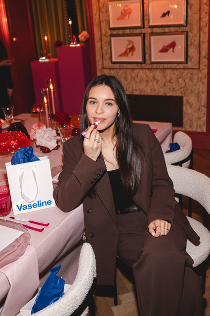 Close-up of guest using Vaseline Gluta-Hya Lip Serum Gloss at branded PR dinner event, photographed by Margot Jakobson, London events photographer