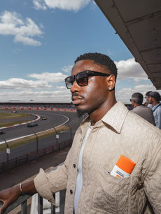 A guest watches the cars trackside with a L'Oreal Paris Men Expert product tucked in his pocket, captured by brand activations photographer Margot Jakobson at Silverstone.
