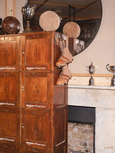 Vintage leather footballs, silver trophies and lace-up boots crown Amazon Influencers lockers beside a marble fireplace, detail captured by London events photographer Margot Jakobson.