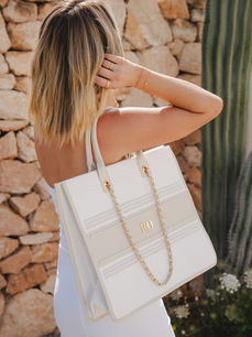 Captured by London Jewellery Photographer Margot Jakobson, a model wears Abbott Lyon jewellery and holds an elegant white Abbott Lyon handbag with gold chain.