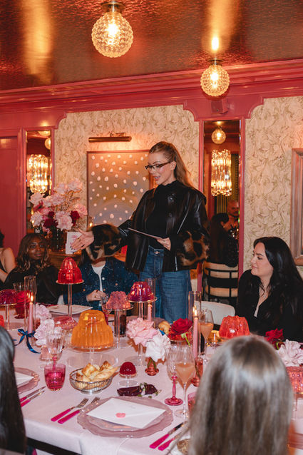 Olivia Attwood addressing guests at Vaseline PR dinner for Gluta-Hya Lip Serum Gloss launch, surrounded by styled tablescape, photographed by London events photographer Margot Jakobson