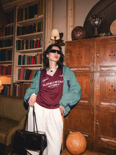 Cool in sunglasses and a burgundy Superstar Sport jersey layered under a teal windbreaker, a guest leans by the lockers, image by London events photographer Margot Jakobson.