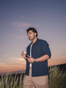 Sunset photo by London events photographer Margot Jakobson of man at L’Oreal Mens Staycation holding L’Oréal Men Expert skincare for mental health and grooming retreat.