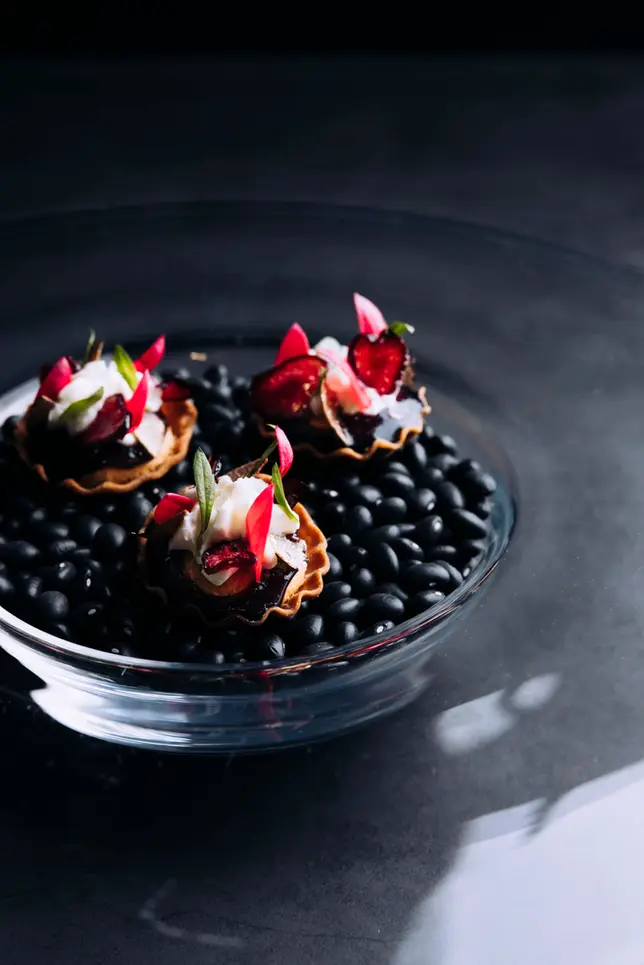 Fermented cherry jam Bakewell tart paired with Ragstone goat’s cheese and garnished with preserved cherry crisps, an elegant dessert that beautifully balances sweet and savoury flavours, ideal for luxury dining experiences.