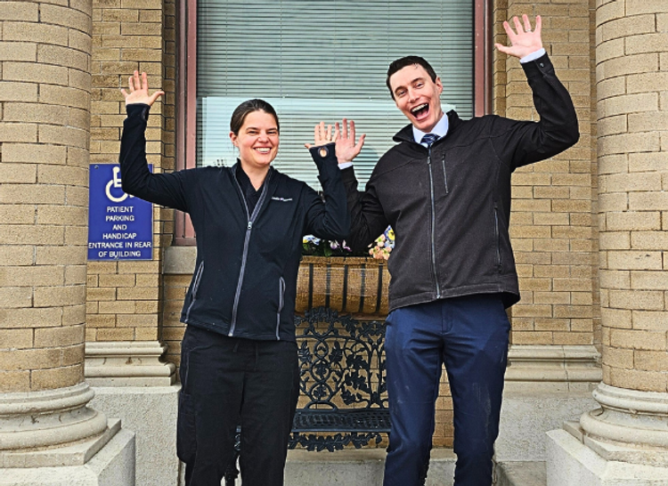 Dr. Heidi Lund and Dr. Alex Lund Stading infront of the white birch dental building