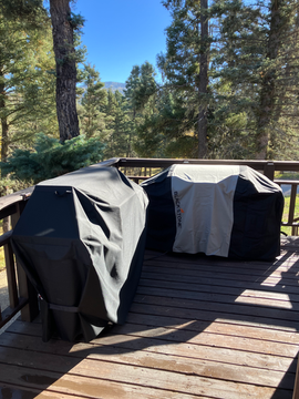 Two covered grills on deck, surrounded by trees and mountains in background. Grilling in Angel Fire