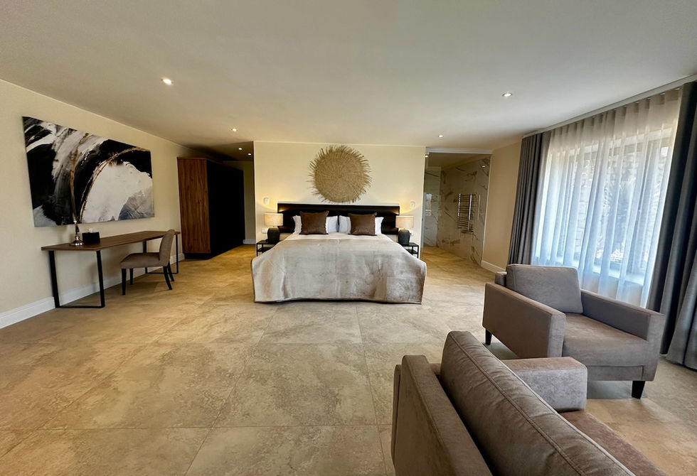 Luxury open-plan Deluxe Apartment bedroom at Cape Vermeer Guesthouse in Somerset West with XL King bed and seating area.