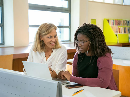 A woman tutoring a high school female student