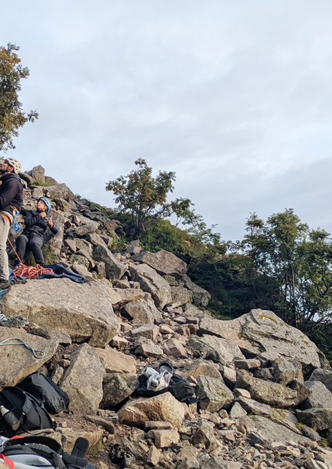 Smiling climbers at the base of the wall during a beginner climbing course in Lofoten