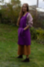 Thumbnail: Women with her hands in deep purple apron's pockets.
