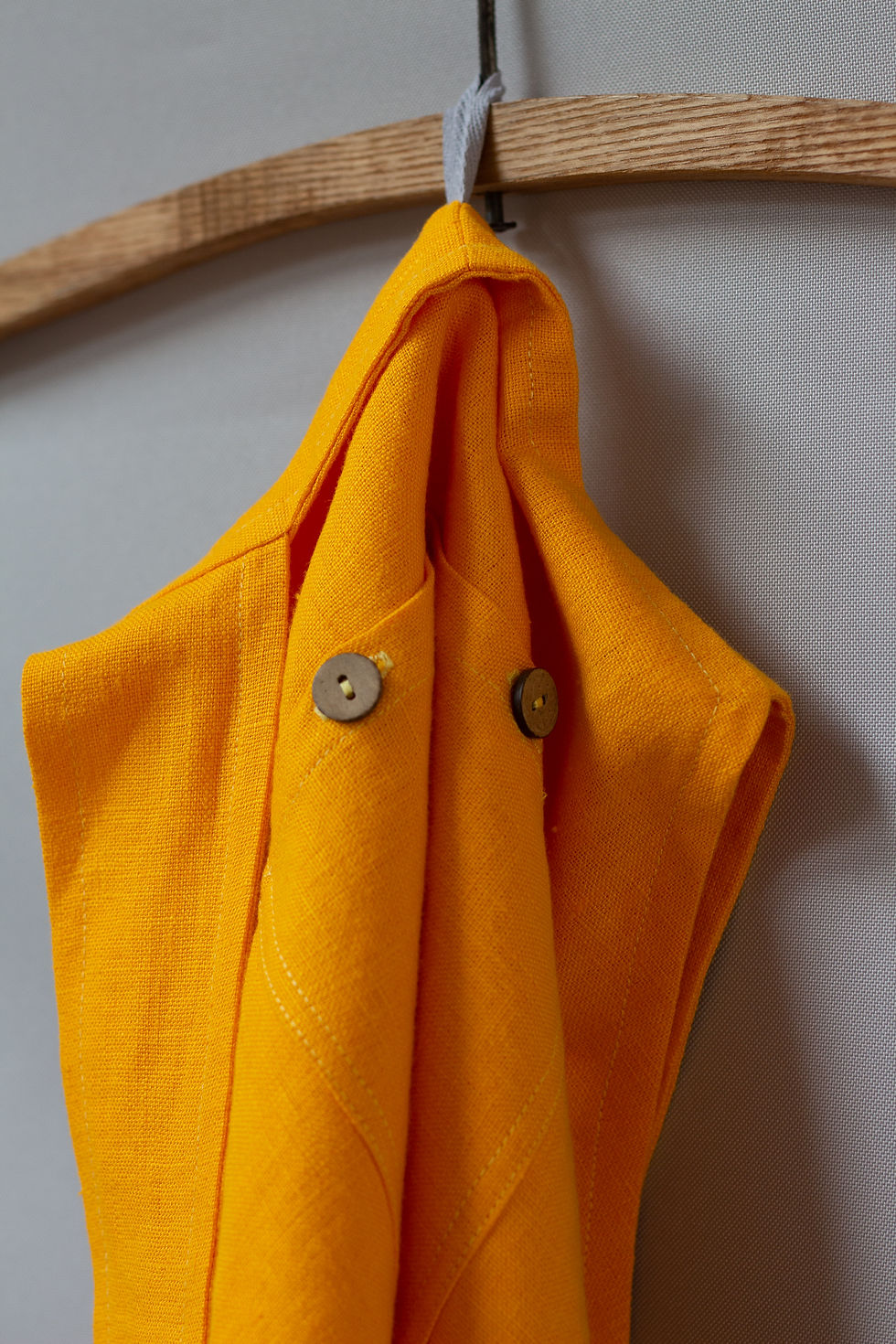 Thumbnail: Deep yellow linen garden apron hanging on the wall