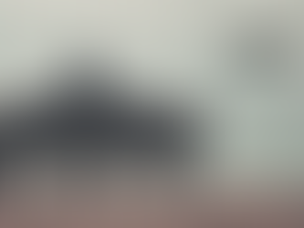 Person sits on a bench facing calm sea, arms outstretched. Overcast sky. Text reads "SMALL PAUSE" in bold black. Peaceful mood.