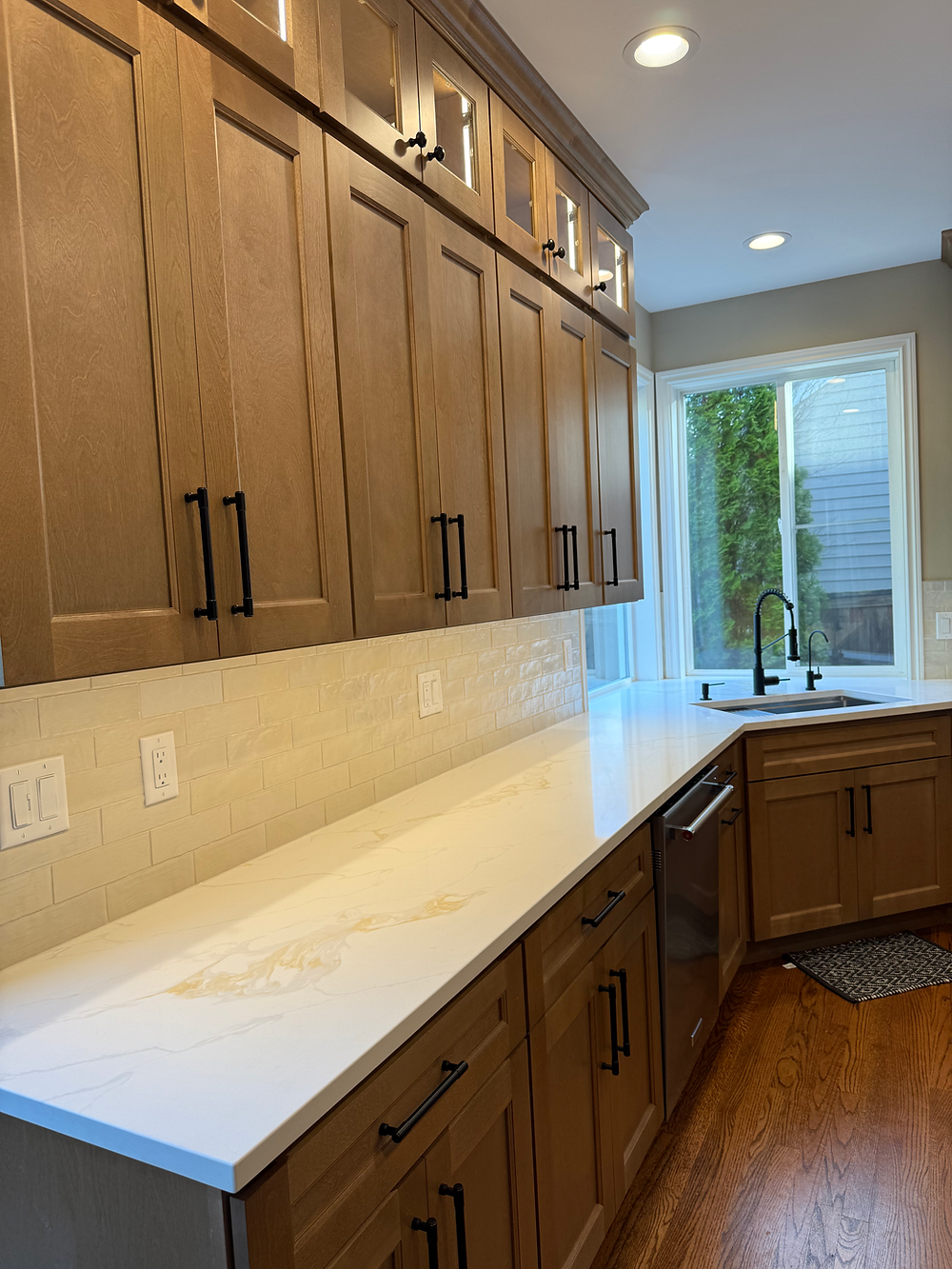 Long quartz countertop with custom wood cabinets in modern Sammamish kitchen remodel.
