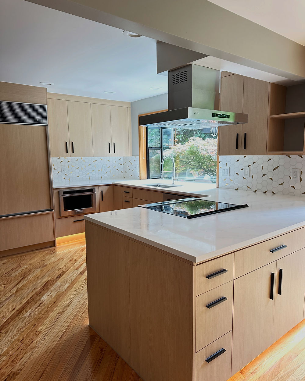 Contemporary Redmond kitchen island with quartz counters and light wood cabinets.