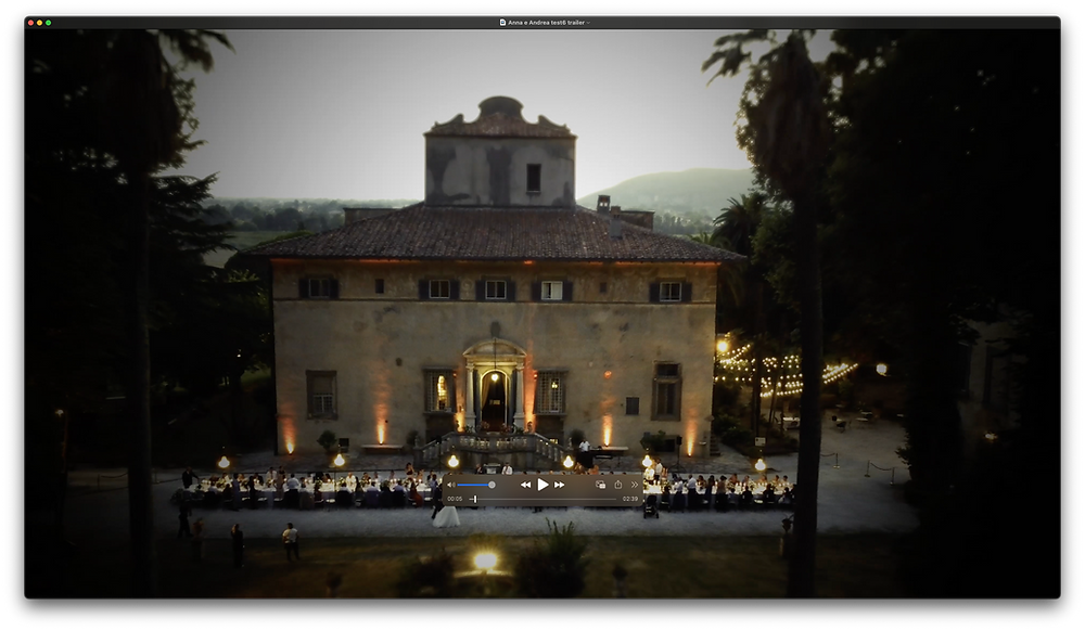 Wide view of a historic Tuscan villa prepared for an outdoor destination wedding reception at sunset.