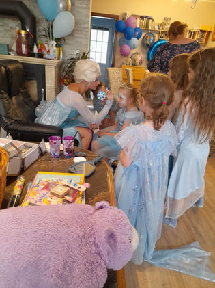 Schneekönigin schminkt Kinder zu Eisprinzessinnen